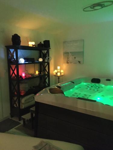 een kamer met een jacuzzi met groene verlichting bij L'INSTANT ZEN NATURISTE ONLY ADULTE in Fresnay-en-Retz