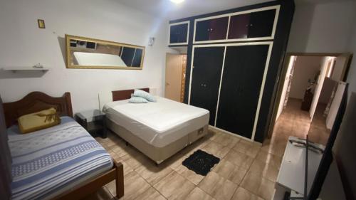 a small bedroom with two beds and a mirror at Suíte aconchegante in Cruzeiro