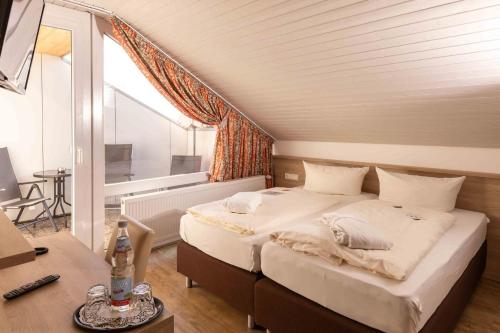 a bedroom with a bed and a desk and a window at Wellnesshotel Sonnenhof & Sonnhalde in Ühlingen-Birkendorf