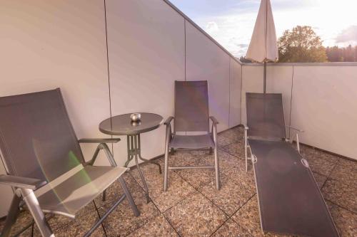 a room with three chairs and a table and a table and chairs at Wellnesshotel Sonnenhof & Sonnhalde in Ühlingen-Birkendorf