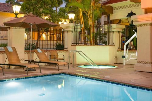 a swimming pool with chairs and an umbrella at Courtyard San Diego Old Town in San Diego