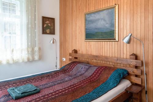 a bedroom with a bed with a lamp and a painting at Vila Jasna in Radovljica