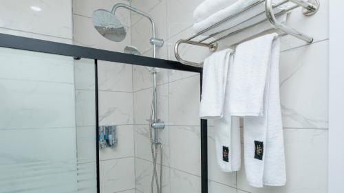 uma casa de banho com um chuveiro e toalhas brancas em Lavender Airport Hotel em Arnavutköy