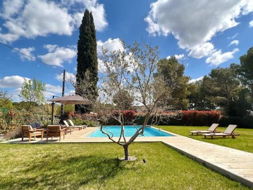- une piscine avec un arbre dans l'herbe dans l'établissement Villa moderne et chaleureuse au milieu vignes et calme absolu à Aix en Provence, à Aix-en-Provence