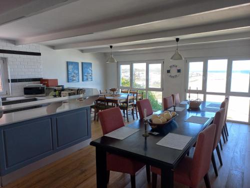 cocina y comedor con mesa y sillas en Swept Away Guesthouse - No-Loadshedding, en Yzerfontein