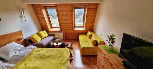 a living room with a couch and a tv at Planinska kuća II in Jahorina