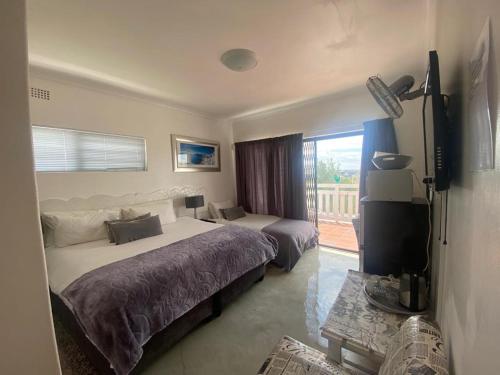 a hotel room with two beds and a television at Au Plais De Langebaan at Palm Tree Villa in Langebaan