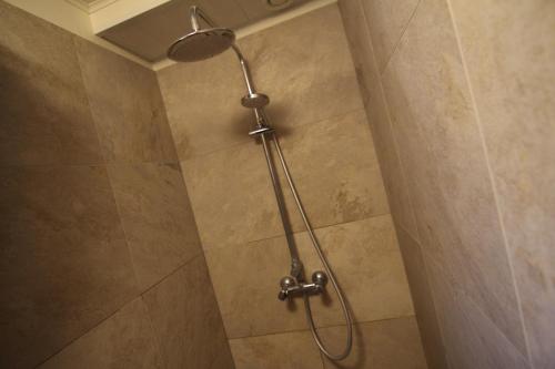 a shower with a shower head in a bathroom at CJA Guesthouse in Laugar