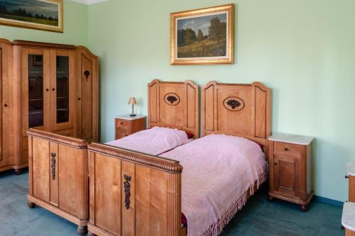 a bedroom with a large wooden bed and wooden cabinets at Vila Jasna in Radovljica