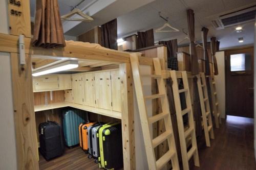 a group of bunk beds in a room with luggage at JAM HOSTEL Hakata Station Front in Fukuoka
