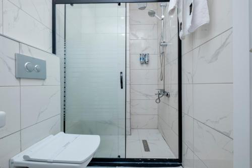 a bathroom with a glass shower with a toilet at Lavender Inn Hotel in Arnavutköy