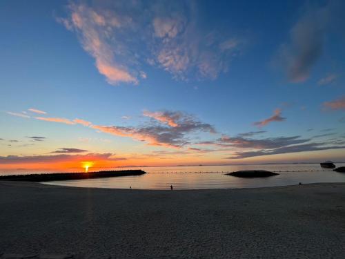 - un coucher de soleil sur une plage au loin dans l'établissement 海に恋する泊まれる喫茶店 ポパイ, à Iyo