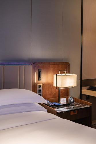 a hotel room with a bed and a lamp at Hilton Fuzhou in Fuzhou