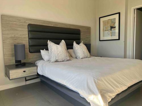 a bedroom with a large bed with white sheets and pillows at 11 @ 7 on Middle Sandton in Johannesburg