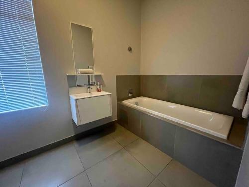 a bathroom with a bath tub and a sink at 11 @ 7 on Middle Sandton in Johannesburg