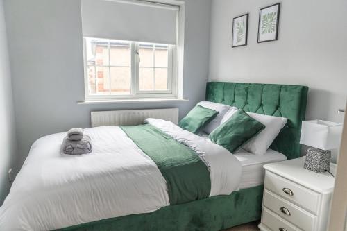 ein Schlafzimmer mit einem grünen und weißen Bett und einem Fenster in der Unterkunft PARKING - HOSPITAL STAFF - Large House - Contractors in Scartho