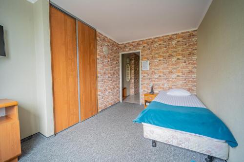 a bedroom with a bed and a brick wall at Hotel Mazowiecki Łódź in Łódź
