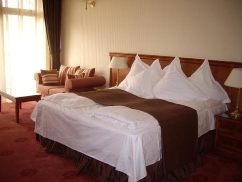 a hotel room with a large bed and a couch at Vila Codrin Neptun-Olimp in Neptun