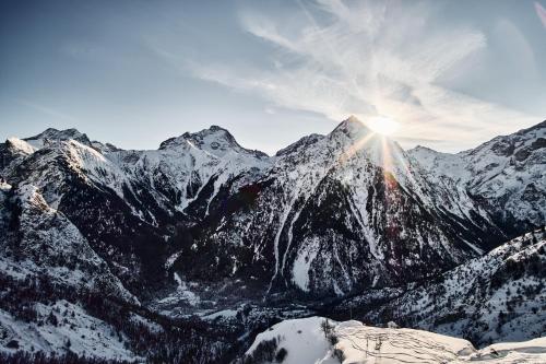 a snow covered mountain with the sun shining on it at 2 Alpes - appartement 2-4 pers in Les Deux Alpes
