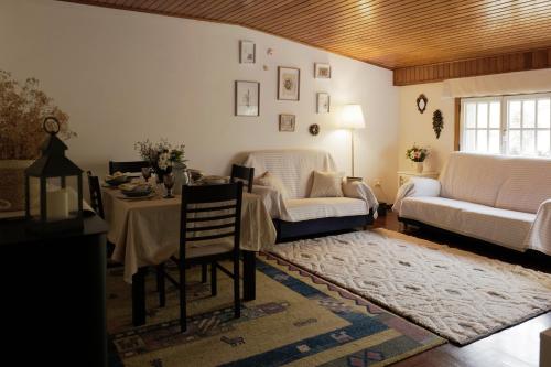 a living room with a table and a couch at "A Fonte Dos Xudíos" Distintivo de Calidad Turística, Hidromasaje y Pet Friendly in Ribadavia