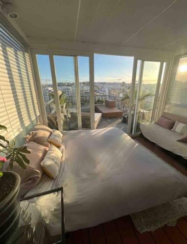 un grande letto in una stanza con ampie finestre di Casa Spinola #SeafrontPenthouse a Paceville