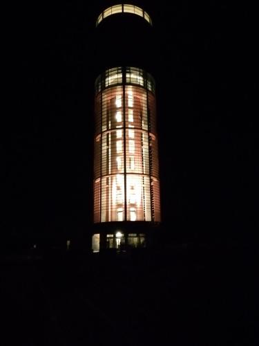 a tall tower at night with its lights on at B&B De Boerderij in Berdorf