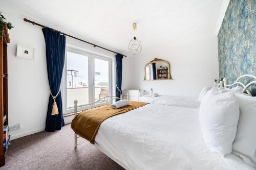 a bedroom with a large bed and a window at Sandy Feet Retreat in South Hayling