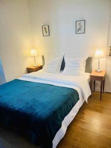 - une chambre avec un grand lit et une couverture bleue et blanche dans l'établissement Maison 50 m2, à 5 minutes de Paris et idéal pour Disney, à Montreuil