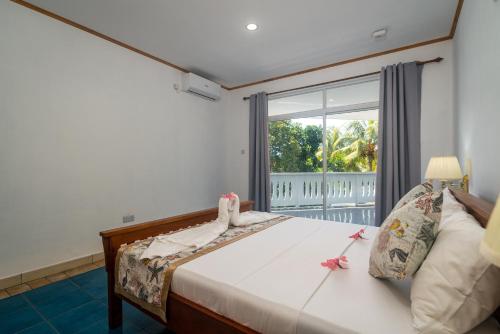 a bedroom with a bed and a large window at 340 Degrees Mountain View Apartments in Anse a La Mouche