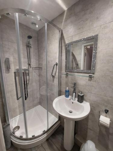ein Bad mit einer Dusche und einem Waschbecken in der Unterkunft Westbrook Lodge Guest House in Margate