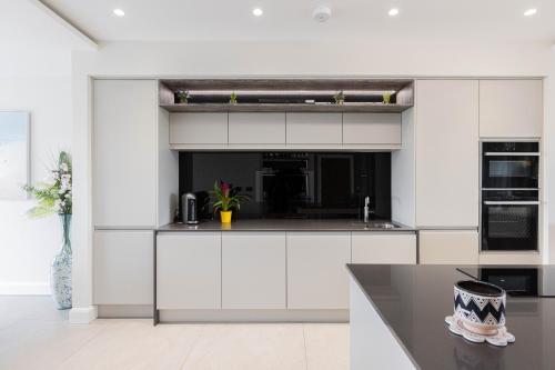a kitchen with white cabinets and a counter top at Curran Gate Luxury Serviced Apartments, Portrush in Portrush