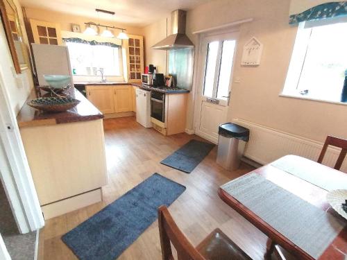 a kitchen with a table and a dining room at Cartref Bach in Llanybyther