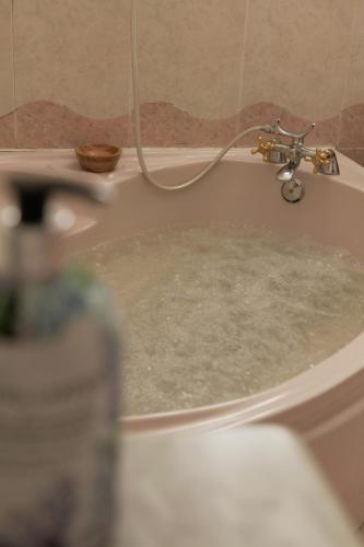 a bath tub filled with water with a faucet at "A Fonte Dos Xudíos" Distintivo de Calidad Turística, Hidromasaje y Pet Friendly in Ribadavia