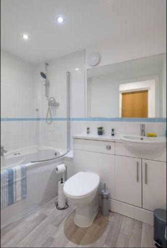 Baño blanco con aseo y lavamanos en Modern 2 Bedroom Flat with Parking in Cardiff, en Cardiff