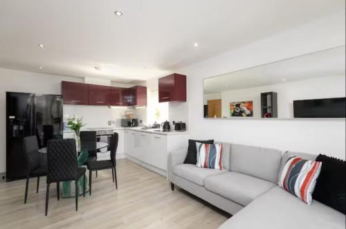 a living room with a couch and a kitchen at Modern 2 Bedroom Flat with Parking in Cardiff in Cardiff