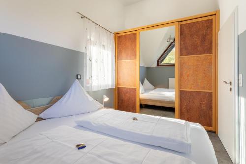 Schlafzimmer mit einem weißen Bett und einem Spiegel in der Unterkunft Sonnendeck 1 in Bad Arolsen