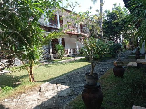 two large vases with trees in front of a building at Sekar Kuning Bungalows in Kuta Lombok