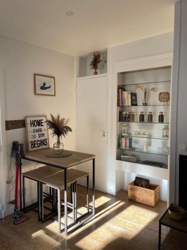 une salle à manger avec une table et une étagère avec des livres dans l'établissement La Duchesse, à Versailles