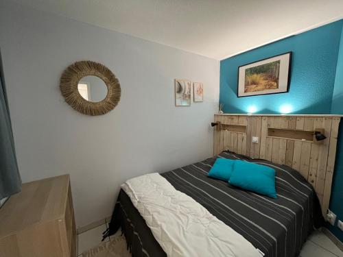 een slaapkamer met een bed met een blauwe muur bij 1101 in Arzon