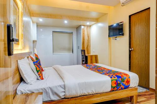 a bedroom with a bed and a flat screen tv at FabHotel Tan Square in Pune
