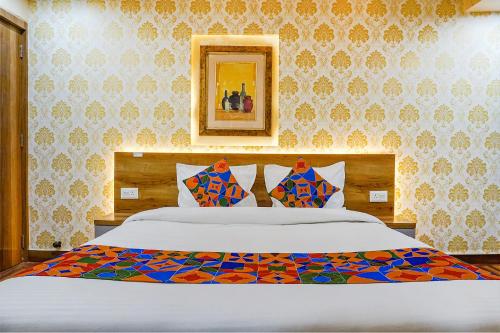 プネにあるFabHotel Tan Squareのベッドルーム1室(模様入りの壁の大型ベッド1台付)