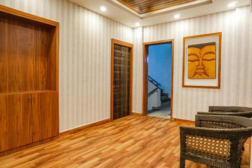a living room with chairs and a painting on the wall at FabHotel Tan Square - Nr Eon IT Park in Pune