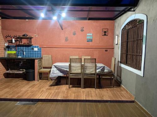 ein Esszimmer mit einem Tisch und Stühlen in einem Zimmer in der Unterkunft Casa em Peruibe 3 dormitórios sendo 1 suite in Peruíbe
