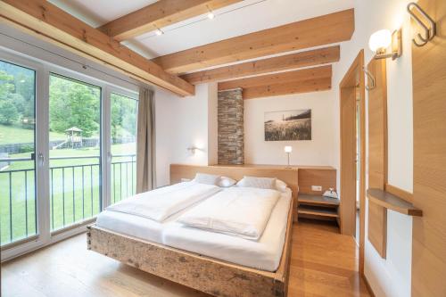 a bedroom with a bed and a large window at Residenz zur Hackenschmiede in Mauterndorf