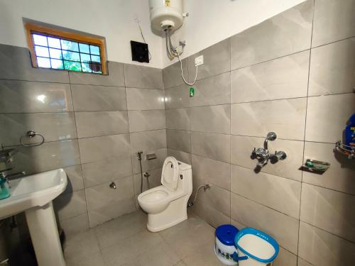 a bathroom with a toilet and a sink at Travelodge Homestay in Bīr