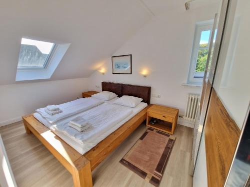 een slaapkamer met een groot bed met een houten frame bij Dünenpark Binz - Komfort Ferienwohnung mit 2 Schlafzimmern und Balkon im Dachgeschoss 047 in Binz