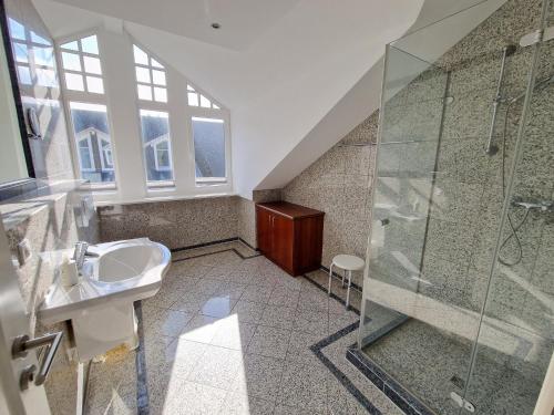 een badkamer met een wastafel en een douche bij Dünenpark Binz - Komfort Ferienwohnung mit 2 Schlafzimmern und Balkon im Dachgeschoss 047 in Binz