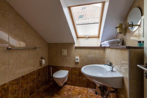 La salle de bains est pourvue d'un lavabo, de toilettes et d'une fenêtre. dans l'établissement Voyage Hotel, à Leipzig