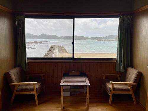 a window in a room with a table and two chairs at 大砂荘 OZUNA CAMP and LODGE in Kaiyo
