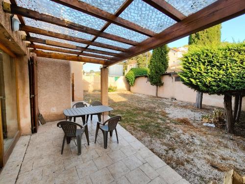 a patio with a table and chairs under a pergola at Votre Évasion Provençale : Villa de Prestige à Marseille in Marseille